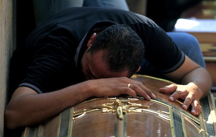A man weeps over the coffin of a Copt killed in clashes in Cairo last year (AP)